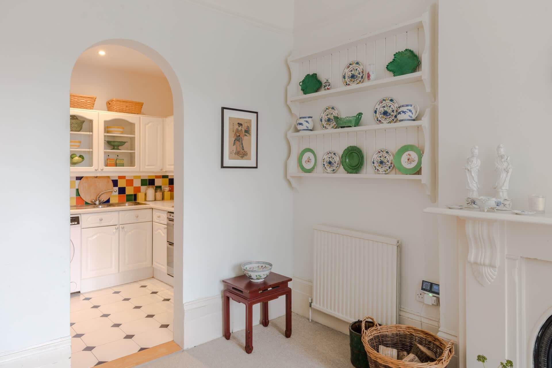 A kitchen with white cabinets, a tiled backsplash, and a dining area with a table and chairs.