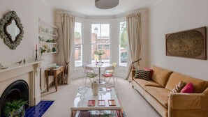 Un salón con chimenea, un sofá, una mesa de centro y vistas al exterior.