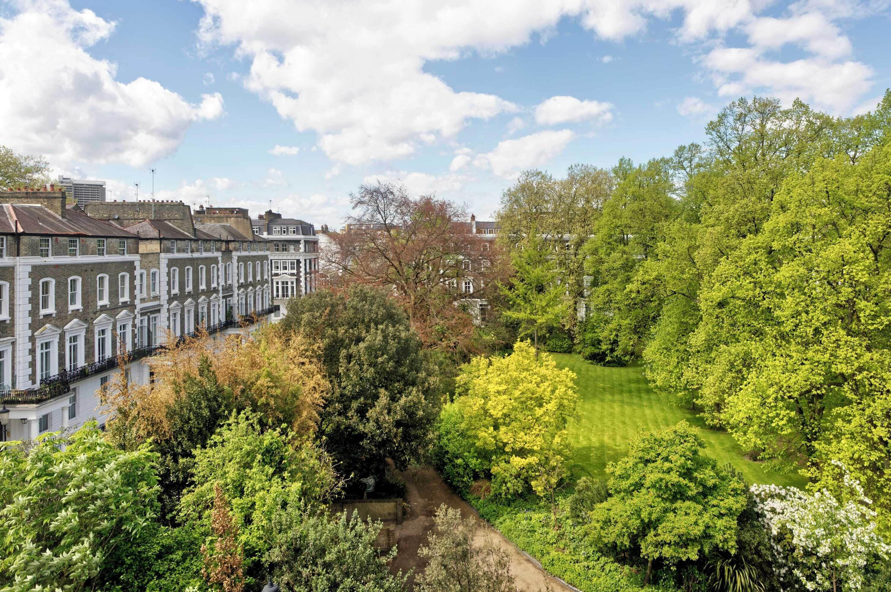 Un quartier résidentiel composé de maisons mitoyennes, d’une pelouse bien entretenue et d’arbres adultes.