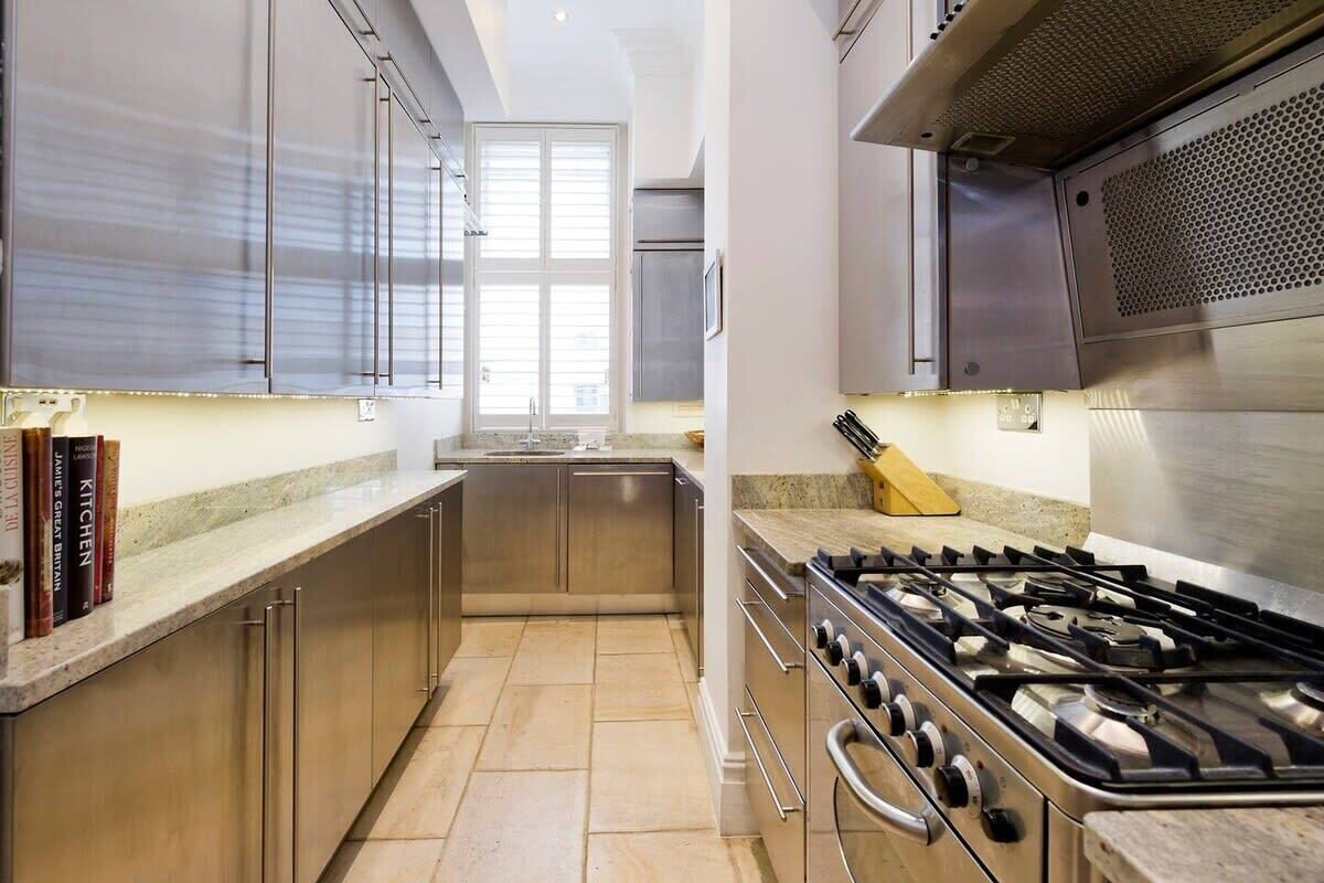 A modern kitchen with stainless steel appliances, a granite countertop, and a view to the outside.