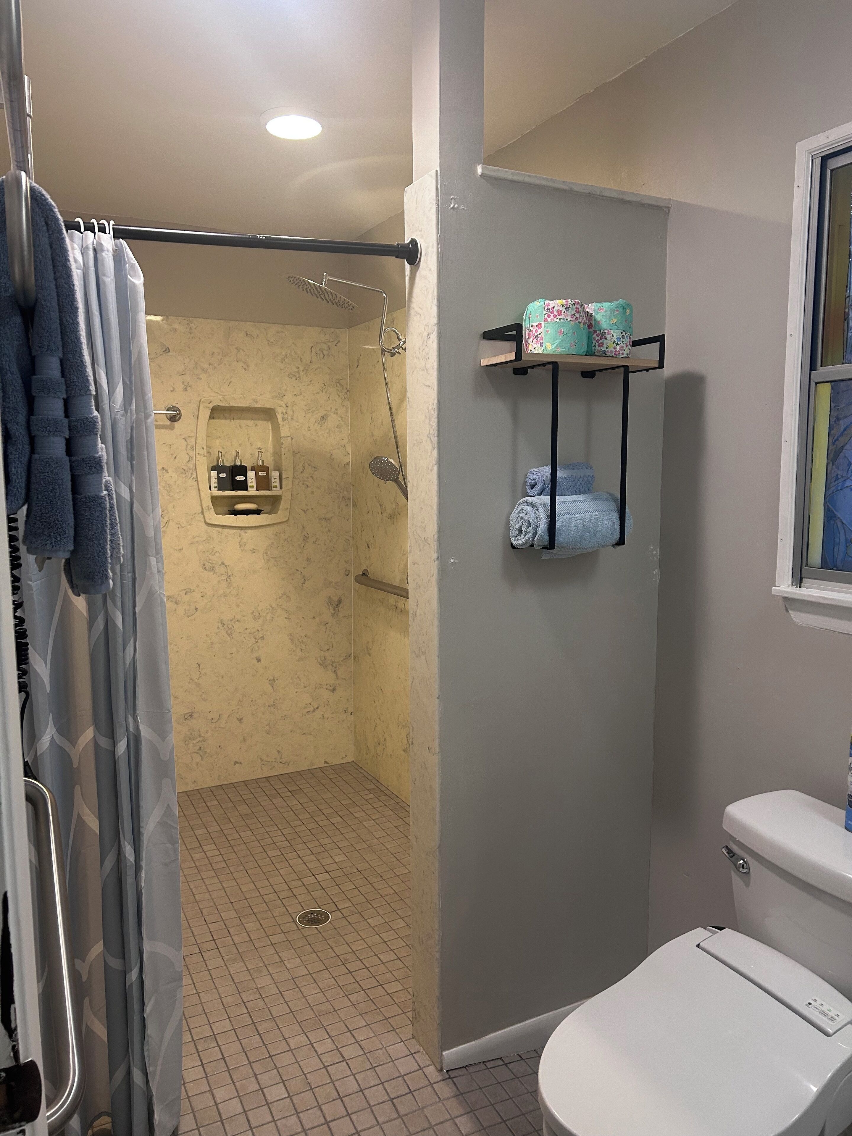 Ein Badezimmer mit Dusche, Toilette und Handtuchhalter.