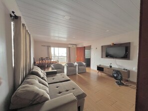 A living room with a sofa, chairs, a TV, and a fan. - 2nd floor apartment near Arena Amazônia Stadium (Alvorada Manaus)