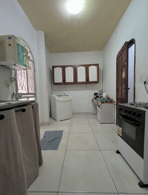 Una cocina funcional con lavadora, estufa y armarios.