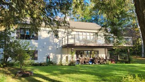 A white house with a balcony and outdoor seating area.
