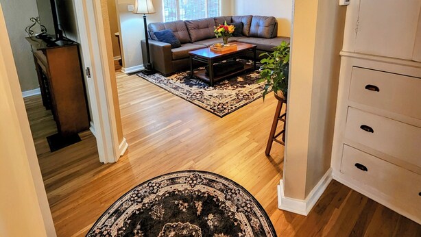 A spacious living room with a sofa, coffee table, and a ceiling fan. - Charming 1938 Pueblo Home with Game Room, Firepit and Boho Bedroom (Pueblo)