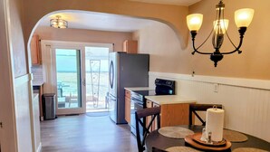 A kitchen with a refrigerator, stove, and dining table with chairs. - Charming 1938 Pueblo Home with Game Room, Firepit and Boho Bedroom (Pueblo)