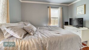 A bedroom with a bed, a TV, and a ceiling fan. - Cozy 3-Bedroom Home – Sleeps 6 (Tulsa)
