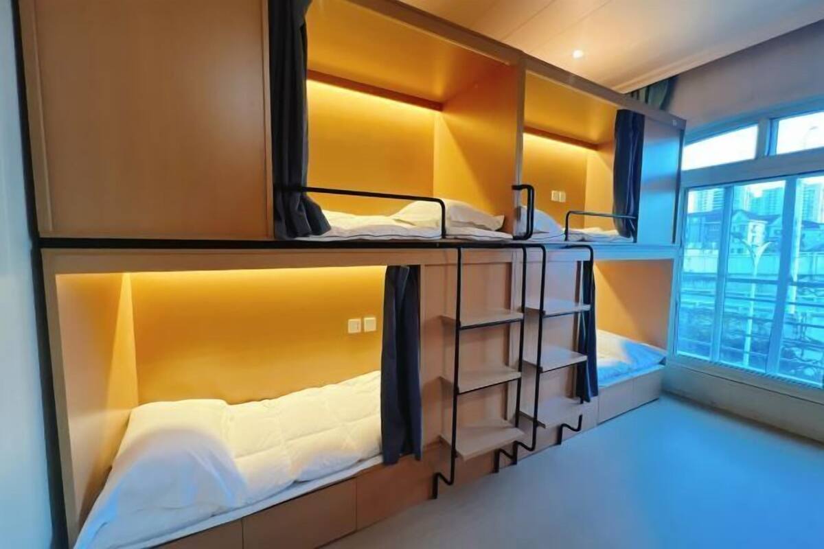Habitación con literas, estantes empotrados y ventana con vistas.