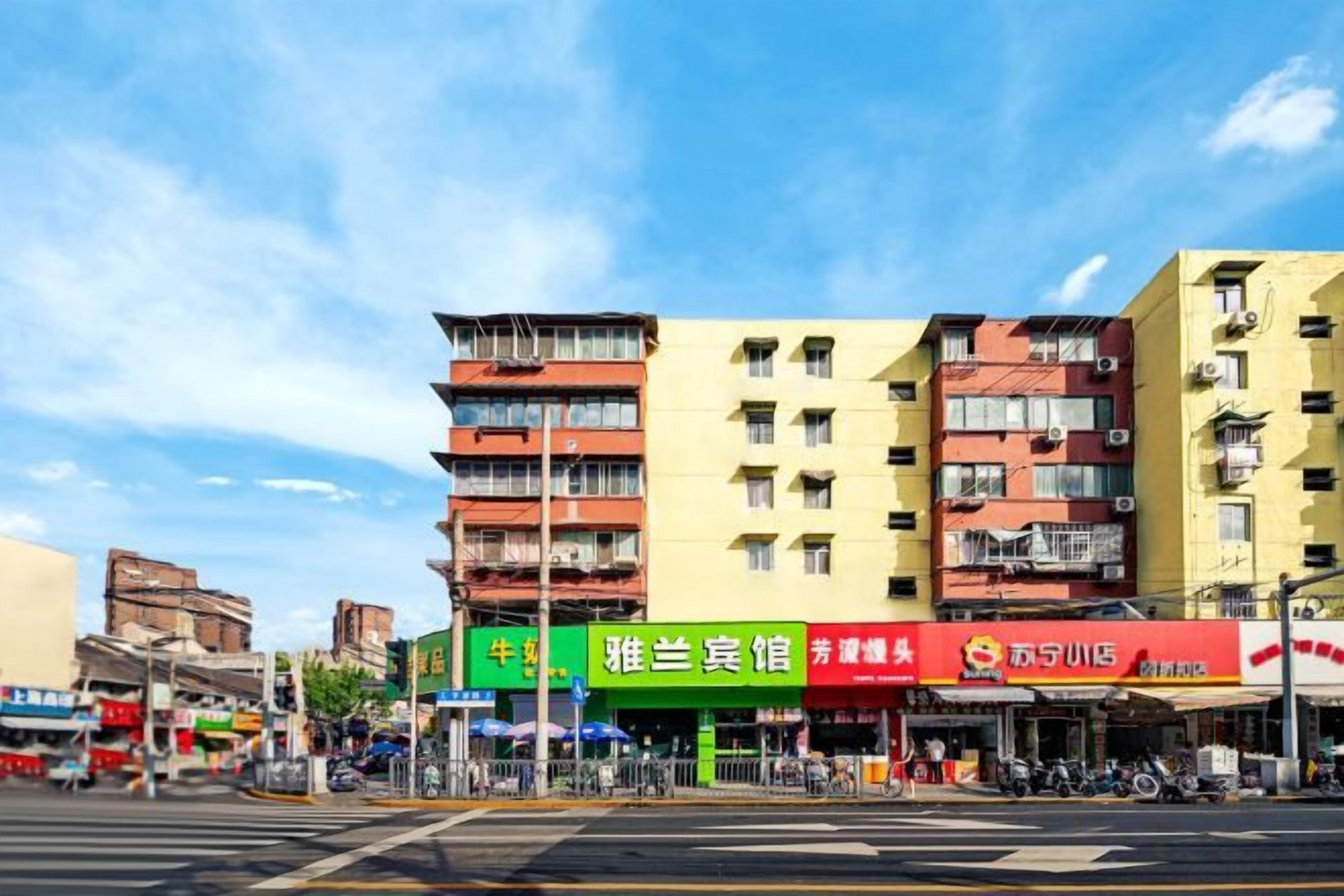 A multi-story building with commercial establishments on the ground floor, including a restaurant and a convenience store.