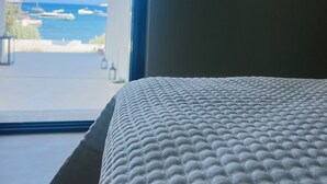 A hotel room with a bed and a view of the sea. - ZELOS Guesthouse Milos (POLLONIAN)