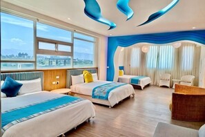 A hotel room with two beds, a desk, and a view of the city. - Tsai Hang B&B (Yilan)