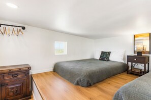 A bedroom with a bed, a dresser, a nightstand, a window, and a mirror. - Carmel in the Sky in Leakey (Leakey)