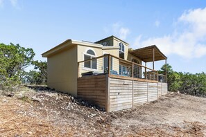 A two-story building with a balcony and a wooden deck.