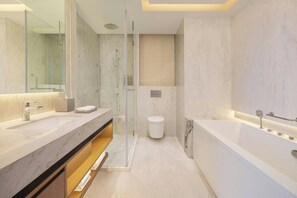 A modern bathroom with a large mirror, two sinks, a shower enclosure, and a bathtub.