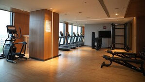 A gym with treadmills, elliptical machines, and weightlifting equipment.
