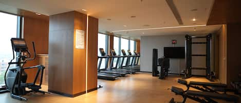 A gym with treadmills, elliptical machines, and weightlifting equipment.