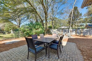 A patio with a table and chairs, surrounded by trees and a brick pathway. - 3 Mi to Beach: Coastal Escape in Mount Pleasant (Mount Pleasant)