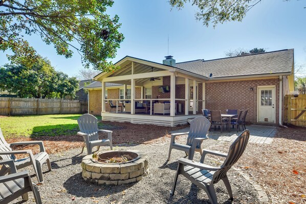 A covered patio with outdoor furniture, a fire pit, and a brick house in the background. - 3 Mi to Beach: Coastal Escape in Mount Pleasant (Mount Pleasant)