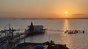 A pier extending into calm water with a building at the end. - Hotel Ayapel Paraiso (Ayapel)