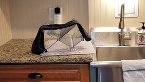 A kitchen with a granite countertop, a black drying rack, a stainless steel sink, and a soap dispenser. - Exclusive 2 Bedroom Garden Level Apartment in Lovely Littleton Colorado! (Littleton)