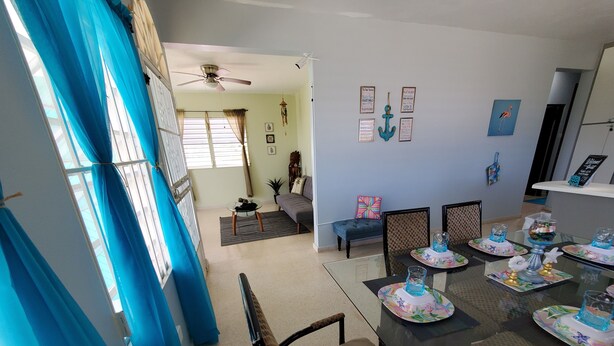 A dining area with a table set for a meal, chairs, and a ceiling fan. - Beautiful home with 2 bedrooms 2 minutes from the beach. (Rincon)