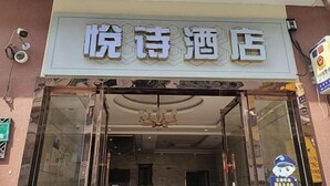 Ein Hotel Eingang mit einem Schild, auf dem '悦诗酒店' steht.