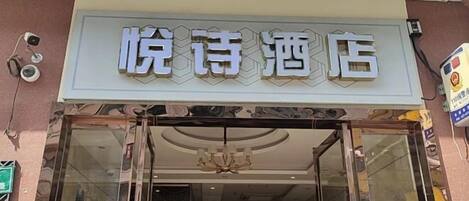 A hotel entrance with a sign that reads "悦诗酒店".
