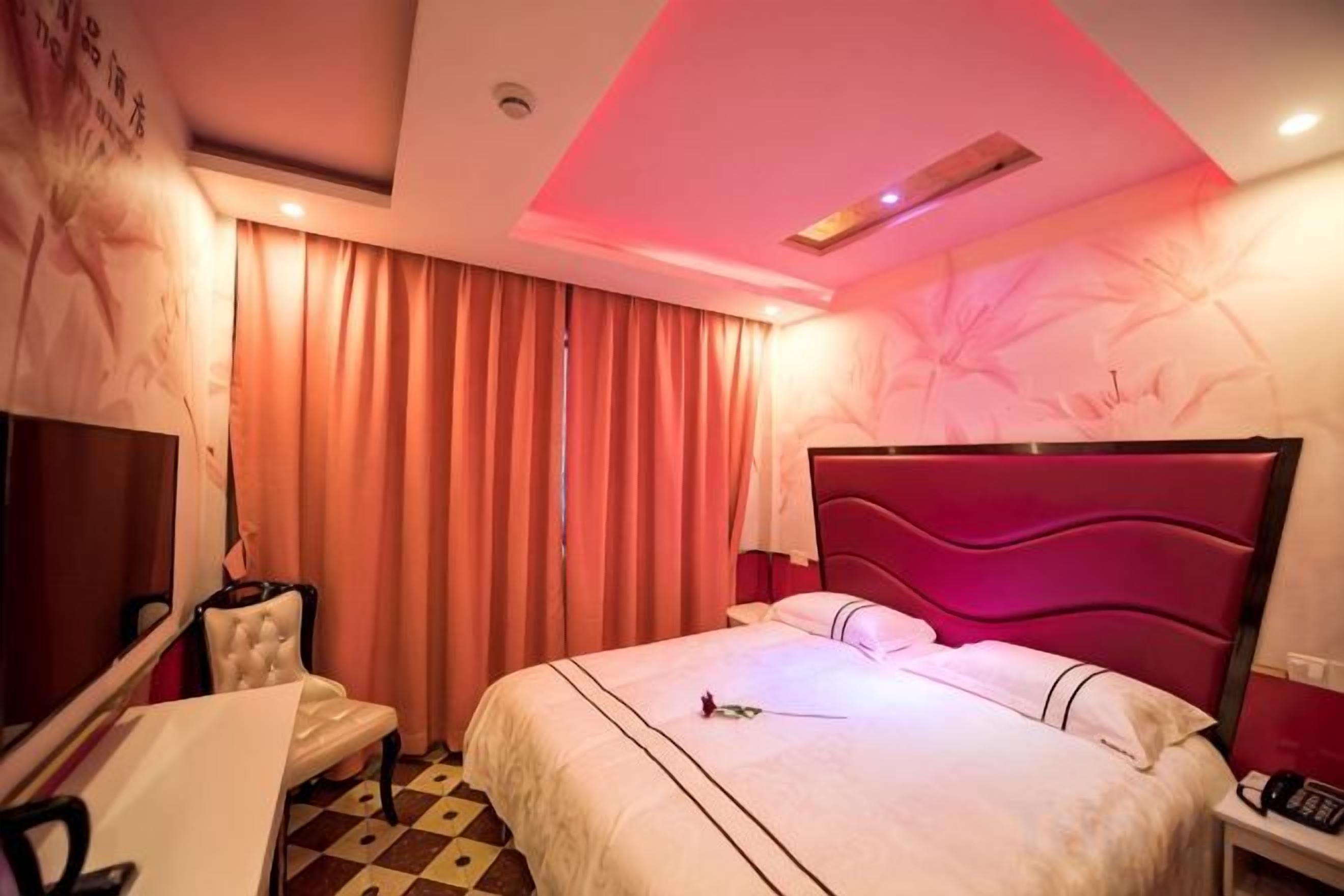 Una habitación de hotel con cama, escritorio, silla y televisión.