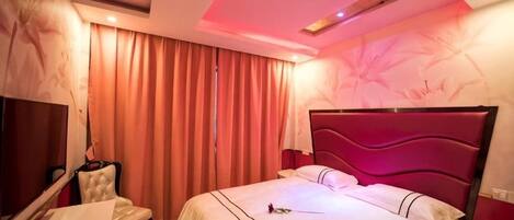 Una habitación de hotel con cama, escritorio, silla y televisión.