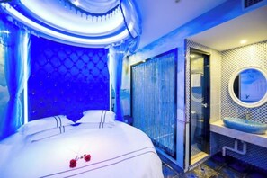 A room with a bed, a bathroom with a sink and mirror, and a glass door leading to another room. - Shanghai Innisfree Hotel (Huancheng East Road Subway Station Branch) (Shanghai)