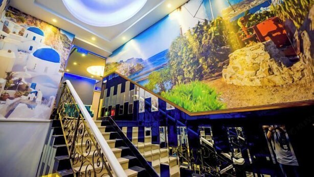 A staircase with a mirrored wall and a mural depicting a coastal scene. - Shanghai Innisfree Hotel (Huancheng East Road Subway Station Branch) (Shanghai)