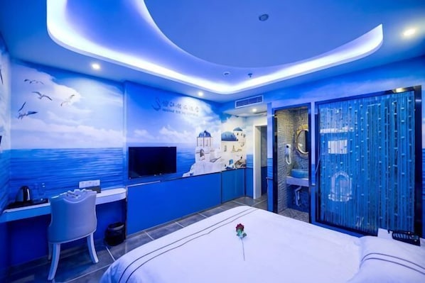 A hotel room with a bed, desk, chair, TV, and a view of the sea. - Shanghai Innisfree Hotel (Huancheng East Road Subway Station Branch) (Shanghai)