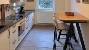 Cocina compacta con ventana, una mesa de comedor y vistas a zonas verdes.