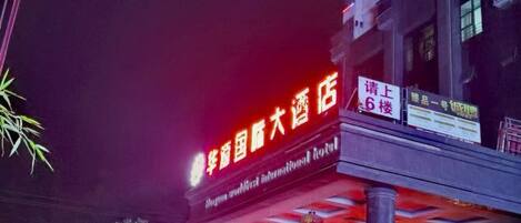 A building with illuminated signage indicating a hotel.
