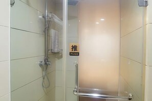 Un espace douche fermé par des parois de verre, équipé d’une barre de poussée et d’un panneau indiquant la présence de cette barre.