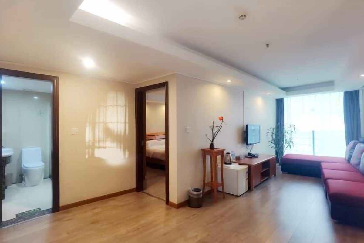 Un salon moderne avec un canapé, un téléviseur, une petite table et un plancher en bois.
