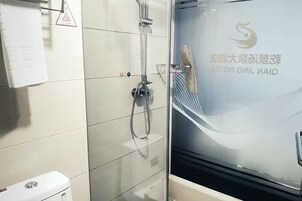 A bathroom with a glass shower enclosure, a towel rack, and a toilet.