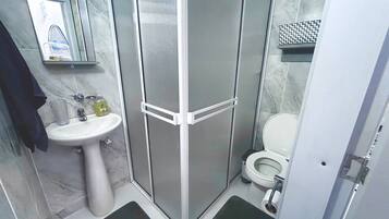 Luxe tweepersoonskamer | Badkamer | Een bad/douchecombinatie, een haardroger, handdoeken, toiletpapier