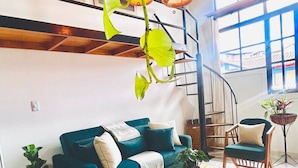 A cozy living room with a blue sofa, a wooden coffee table, and a hanging plant. - Boutique Stay Near Pereira (Dosquebradas)