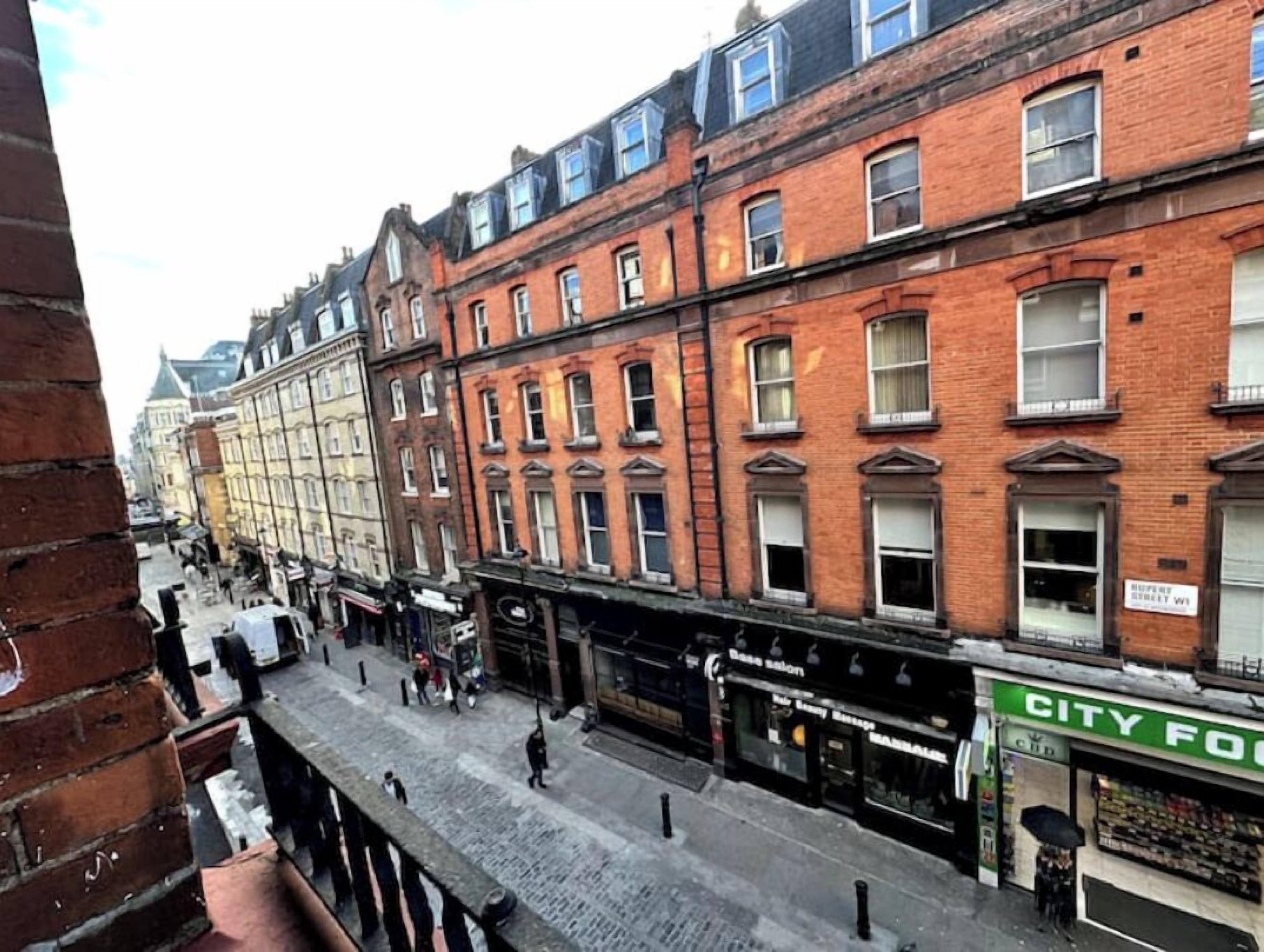 Une vue de rue avec des immeubles, des boutiques et des piétons.