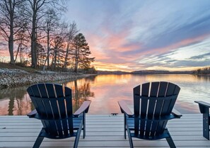 Two Adirondack chairs facing a calm lake at sunset with trees on the left. - Sunkissed Shores-Rare Flat Lot w/Beautiful Views, Dock, Hot Tub (Winchester)