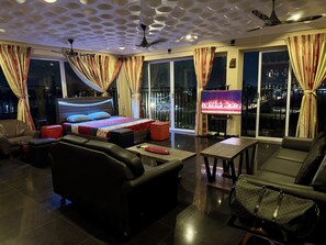 Relax in a spacious room with a large bed, flat-screen TV, and seating area.