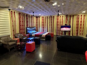 Relax in this stylish living room with a large bed, leather sofas, and a flat-screen TV.