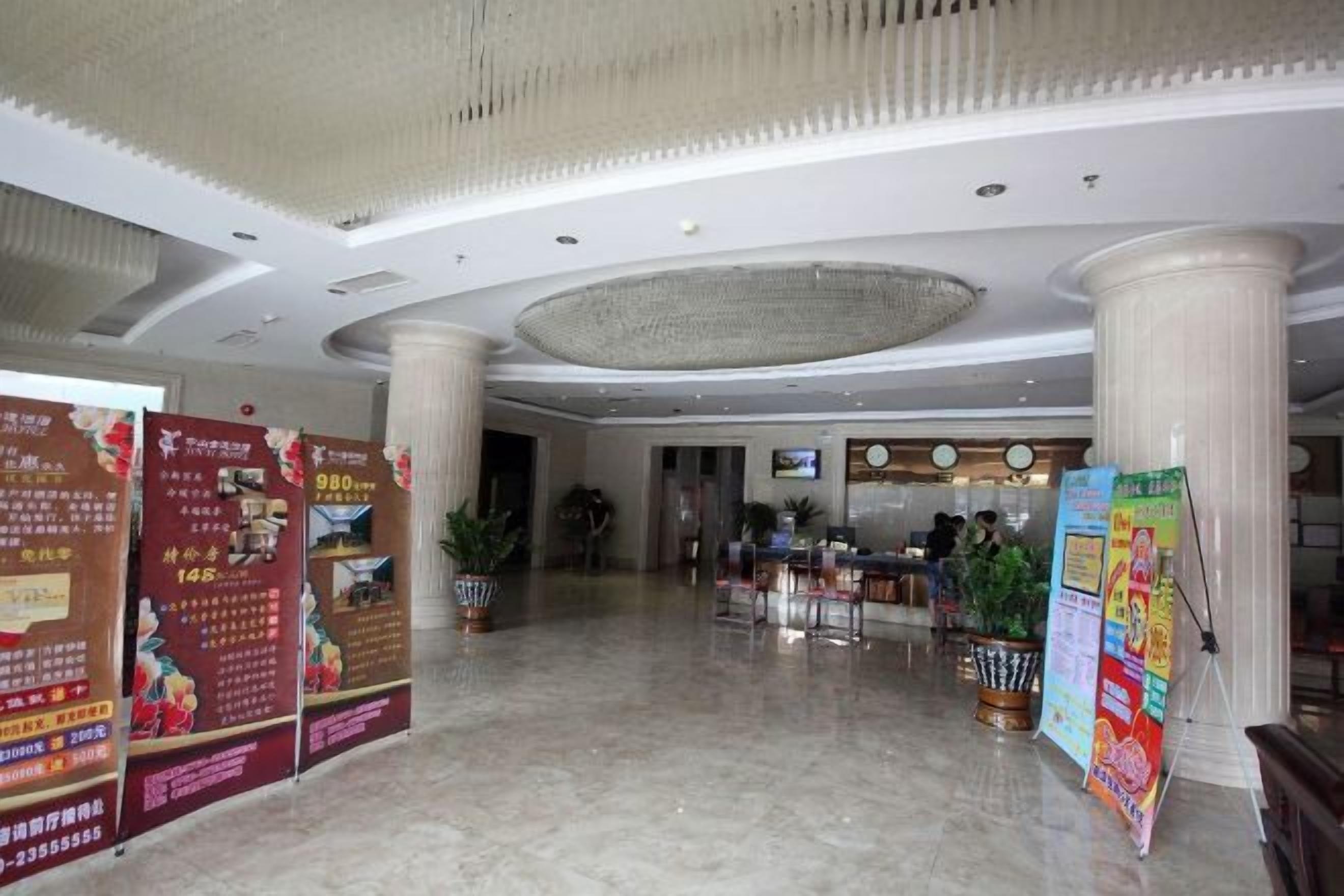 A spacious lobby with marble flooring, large columns, and informational posters.