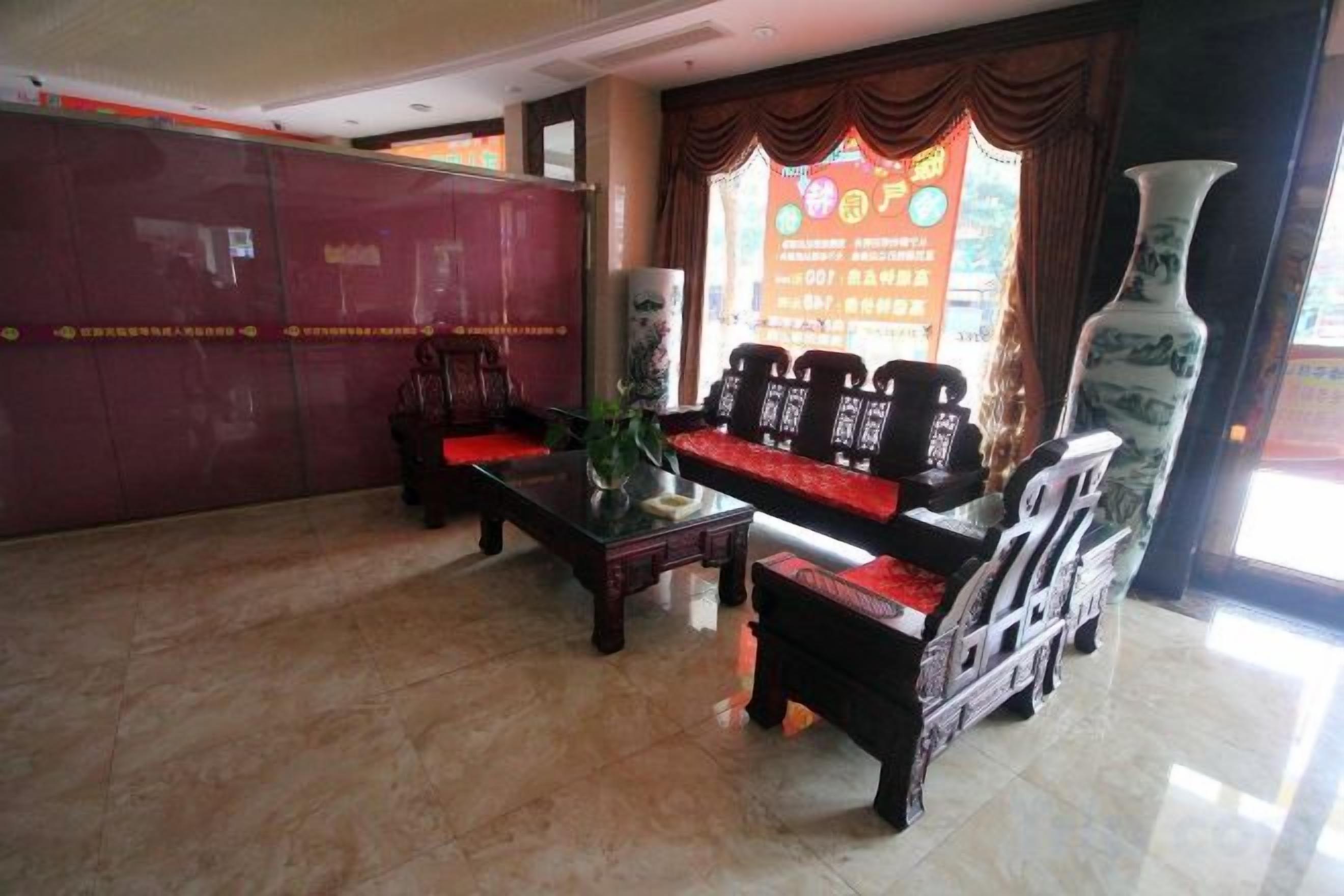 A lobby with a reception desk, seating area, and a large vase.