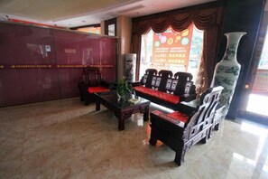 A lobby with a reception desk, seating area, and a large vase. - Saiyan Hotel (Zhongshan Bus Terminal) (Zhongshan)