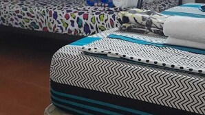 A dormitory room with bunk beds, a small table, and a chair.