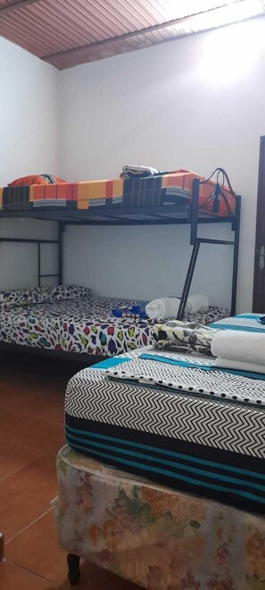 Une chambre de dortoir avec des lits superposés, une petite table et une chaise.
