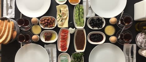 Una mesa lista para el desayuno con diversos platos y aderezos.