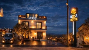 A hotel named 'ROSE HOTEL' with a two-story structure, a visible entrance, and a signboard. - Rose Otel (Ezine)